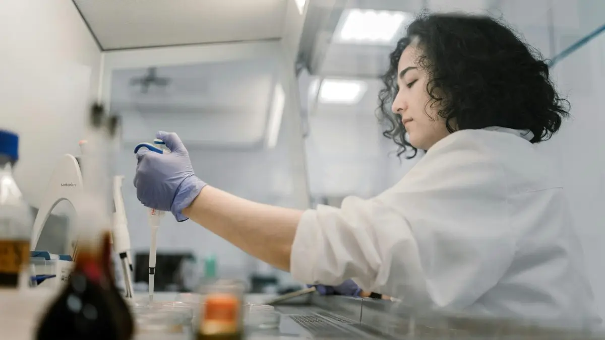 Kobieta naukowiec obsługująca próbkę w laboratorium.